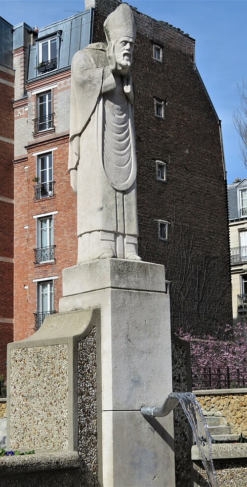 A statue of Saint Denis holding his head in his hands